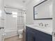 Bright bathroom featuring a tub with tiled walls and a modern blue vanity with white countertop at 5834 71St N St, St Petersburg, FL 33709