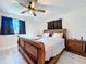 Cozy bedroom with a ceiling fan, dark curtains, and a wooden sleigh bed at 620 43Rd Street W Blvd, Palmetto, FL 34221