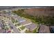 An aerial view of a neighborhood with a dense tree line and a beautiful blue sky backdrop at 7580 Pool Compass Loop, Wesley Chapel, FL 33545