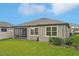 A well-maintained backyard features a screened-in patio, tidy lawn, and tidy shrubbery providing a serene retreat at 7580 Pool Compass Loop, Wesley Chapel, FL 33545