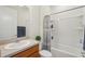 Clean bathroom features a shower/tub combo and wood cabinets at 7580 Pool Compass Loop, Wesley Chapel, FL 33545