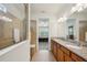 Bathroom features a large glass-enclosed tiled shower with double vanity and granite countertops at 7580 Pool Compass Loop, Wesley Chapel, FL 33545