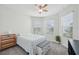 Bright bedroom features two windows, ceiling fan, and neutral carpet and walls at 7580 Pool Compass Loop, Wesley Chapel, FL 33545