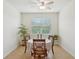 Charming dining room featuring a table for four, tile flooring, and a bright window at 7580 Pool Compass Loop, Wesley Chapel, FL 33545