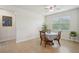 Bright dining area with tile flooring, a ceiling fan, a window, and a table for four at 7580 Pool Compass Loop, Wesley Chapel, FL 33545