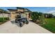 Beautiful home exterior with a well-manicured lawn and modern golf cart parked in the driveway at 7580 Pool Compass Loop, Wesley Chapel, FL 33545