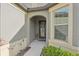 Welcoming front entrance with arched entryway and decorative floral wreath at 7580 Pool Compass Loop, Wesley Chapel, FL 33545
