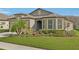 Beautiful home showcasing lush landscaping, flowering bushes, and a well-maintained lawn at 7580 Pool Compass Loop, Wesley Chapel, FL 33545