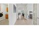 Bright hallway leading to laundry room, living spaces and home office with glass french doors at 7580 Pool Compass Loop, Wesley Chapel, FL 33545