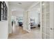 Bright hallway featuring tile floors and archways to living spaces and home office with glass french doors at 7580 Pool Compass Loop, Wesley Chapel, FL 33545