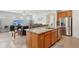 Open-concept kitchen with granite countertops, stainless steel appliances and an island with a sink and seating at 7580 Pool Compass Loop, Wesley Chapel, FL 33545
