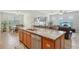 Open-concept kitchen island with stainless steel dishwasher and a view into dining and living spaces at 7580 Pool Compass Loop, Wesley Chapel, FL 33545