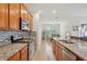Modern kitchen featuring stainless steel appliances, granite countertops, and an open view to the dining area at 7580 Pool Compass Loop, Wesley Chapel, FL 33545
