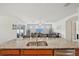 Kitchen island with granite countertops and stainless sink with an open view to living room and outdoor patio at 7580 Pool Compass Loop, Wesley Chapel, FL 33545