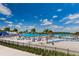 A stunning lagoon view showcases a clear turquoise waters, sandy beaches, palm trees, and beach amenities creating a tropical escape at 7580 Pool Compass Loop, Wesley Chapel, FL 33545