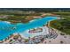 An expansive lagoon offers clear turquoise waters, sandy beaches, palm trees, comfortable seating, and water activities for residents at 7580 Pool Compass Loop, Wesley Chapel, FL 33545