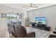 Spacious living room with ceiling fan, neutral decor, and sliding door to outdoor space at 7580 Pool Compass Loop, Wesley Chapel, FL 33545
