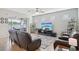 Spacious living room with tile flooring, ceiling fan, comfortable seating, and sliding door to outdoor space at 7580 Pool Compass Loop, Wesley Chapel, FL 33545