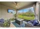 Relax on this screened lanai with a mounted television, fire pit, and serene backyard views at 7580 Pool Compass Loop, Wesley Chapel, FL 33545