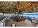 Spacious outdoor tiki bar with wood accents and waterfront views, perfect for entertaining guests and enjoying lakeside refreshments at 7580 Pool Compass Loop, Wesley Chapel, FL 33545