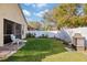 Spacious backyard with lush green grass, white fence, and lounging area at 8315 Moccasin Trail Dr, Riverview, FL 33578