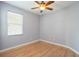 This bedroom has hardwood floors, a ceiling fan, a window, and is painted a neutral color at 8315 Moccasin Trail Dr, Riverview, FL 33578
