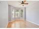 This bright bedroom features a ceiling fan, hardwood floors, and three large windows at 8315 Moccasin Trail Dr, Riverview, FL 33578