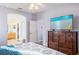 Bright bedroom with a large wooden dresser and a view into the ensuite bathroom at 8315 Moccasin Trail Dr, Riverview, FL 33578