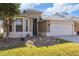 Exterior front elevation of home with a two car garage, landscaping, and yard at 8315 Moccasin Trail Dr, Riverview, FL 33578