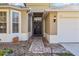 Inviting front entrance with a brick walkway, potted plants, coach lights and a decorative front door at 8315 Moccasin Trail Dr, Riverview, FL 33578