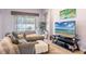 Comfortable living room showcasing a sectional sofa, entertainment center, and sliding glass doors to the patio at 8315 Moccasin Trail Dr, Riverview, FL 33578