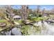 Beautiful backyard featuring lush landscaping, a dock, a charming pond and mature trees at 8922 Donna Lu Dr, Odessa, FL 33556