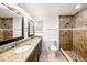 Tastefully updated bathroom with double sinks, granite counters, and a walk-in shower at 8922 Donna Lu Dr, Odessa, FL 33556