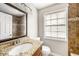 Bathroom with granite vanity, tiled shower, large mirror and natural light from a window at 8922 Donna Lu Dr, Odessa, FL 33556