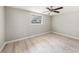 Bright bedroom featuring wood-look floors, neutral walls, a ceiling fan, and a window allowing natural light at 8922 Donna Lu Dr, Odessa, FL 33556