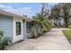 Close up of single-story home featuring light blue siding, palm trees and a paved drive way at 8922 Donna Lu Dr, Odessa, FL 33556