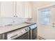 Well-lit laundry room with new machines, white cabinets and a stylish door at 112 17Th E St, Bradenton, FL 34208