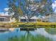 Backyard view features serene lake, a lush lawn, and mature tree, enhancing the property's privacy at 1204 50Th E St, Bradenton, FL 34208