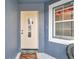 Close-up of a welcoming front entrance featuring a decorative door, adjacent window, and painted blue walls at 1204 50Th E St, Bradenton, FL 34208