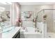 Bright, neutral bathroom featuring double sinks, soaking tub, and glass shower at 13218 Satin Lily Dr, Riverview, FL 33579