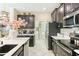 Modern kitchen with dark cabinetry, stainless steel appliances, and white countertops at 13218 Satin Lily Dr, Riverview, FL 33579