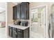 Kitchen featuring sleek black cabinets, white countertops, and access to a laundry room at 13218 Satin Lily Dr, Riverview, FL 33579