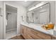 Modern bathroom featuring a vanity with stylish mirror, sink, and a glass-enclosed tiled shower at 14766 Feather Cove Ln, Clearwater, FL 33762