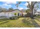 Inviting home exterior with manicured lawn, complemented by palm trees, flower beds and a two-car garage at 14766 Feather Cove Ln, Clearwater, FL 33762