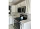 Modern kitchen equipped with stainless steel appliances, sleek white cabinets, and elegant quartz countertops for a luxurious cooking experience at 14766 Feather Cove Ln, Clearwater, FL 33762