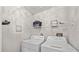 Efficient laundry room equipped with a washer, dryer, shelving and ample space at 14766 Feather Cove Ln, Clearwater, FL 33762