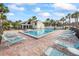 Community pool with lounge chairs and tropical landscaping on a sunny day at 14766 Feather Cove Ln, Clearwater, FL 33762