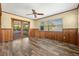 Bright living room featuring wood-look floors, wood trim, a ceiling fan, and sliding glass doors at 1801 38Th N St, St Petersburg, FL 33713