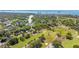 Wide aerial view showcasing the golf course adjacent to a residential neighborhood, surrounded by lush greenery and trees at 2016 Culberson Ave, Dunedin, FL 34698