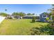 Spacious backyard features lush green grass, shed, barbeque, and an enclosed screened patio at 2016 Culberson Ave, Dunedin, FL 34698
